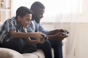Black father and son playing video games